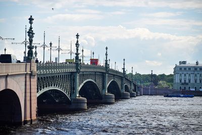 Arch bridge over river against buildings in city