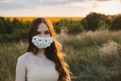 Close-up of young woman wearing mask standing outdoors