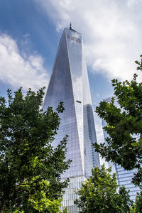 Low angle view of skyscrapers against cloudy sky