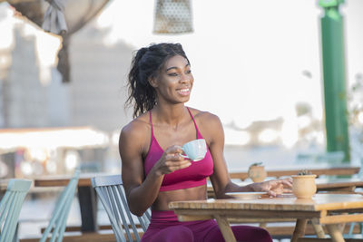 Happy young woman sitting on table