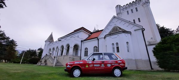 Vintage car by building against sky