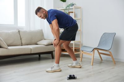 Side view of man exercising on hardwood floor