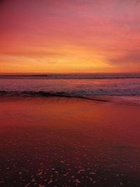 Scenic view of sea against dramatic sky during sunset