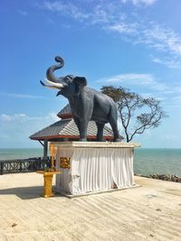 View of statue by sea against sky