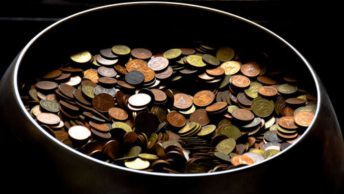 High angle view of coins in bowl on table