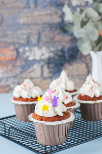 Carrot cake cupcakes with cream cheese frosting with sprinkles. close up. copy space.