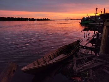 Boat in sea against sky during sunset