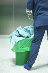 Low section of man standing by garbage bin in hospital