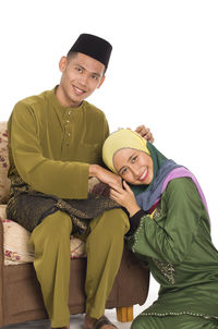 Portrait of couple holding hands against white background