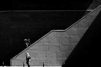 People standing by railing against wall