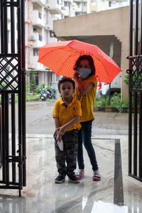 Full length of boy with umbrella during rainy season