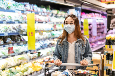 Woman wearing flu mask standing in store