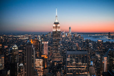 High angle view of illuminated empire state building and city against clear blue sky at night