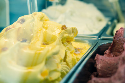 Close-up of ice cream seen through glass at store