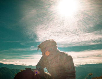 Portrait of young man against sun on sunny day