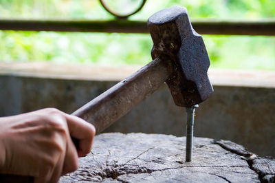 Close-up of hand hammering nail on wood