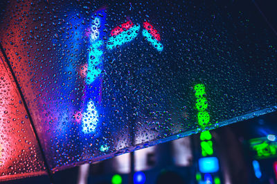 Close-up of wet illuminated glass during rainy season