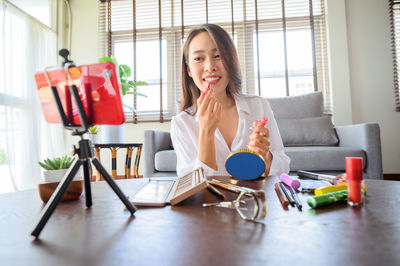 Woman sitting on table at home