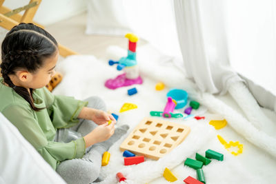 High angle view of girl playing with toy at home