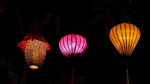 Low angle view of illuminated lanterns hanging at night