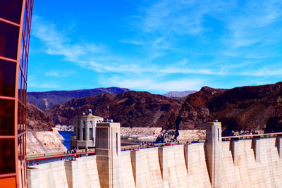 Scenic view of dam and mountains against blue sky