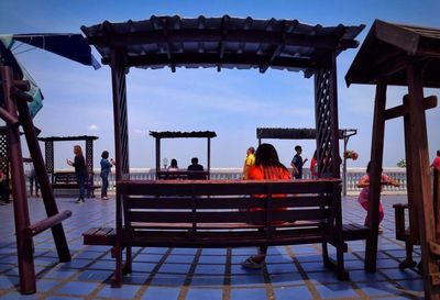 People sitting at observation point against sky