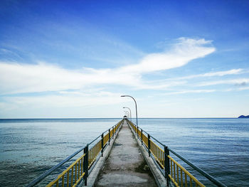 Narrow jetty leading to calm blue sea