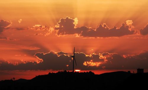 Silhouette windmill against sky during sunset