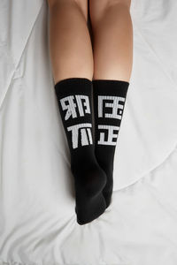 Low section of woman lying on bed