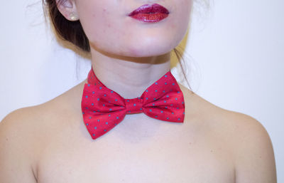 Midsection of woman wearing red bow tie and lipstick