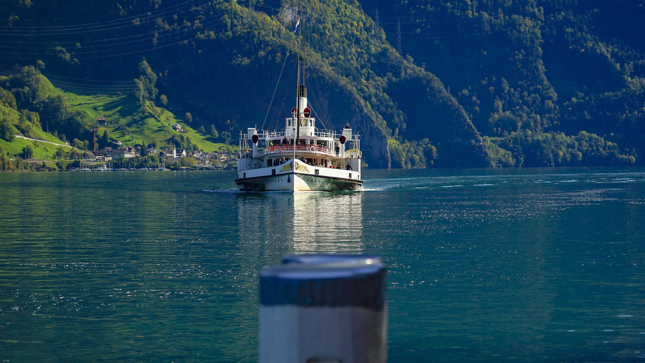 SHIP SAILING ON SEA AGAINST MOUNTAIN