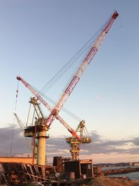 Cranes at construction site against sky