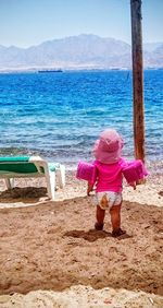 Rear view of woman standing on beach