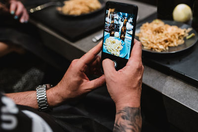 From above unrecognizable person using smartphone to take photo of tasty dish after lesson in cooking workshop in navarre, spain person