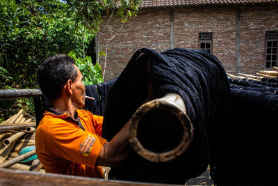  the craftsmen do  dyeing process of the fabric lurik in tringsing village,  java, indonesia
