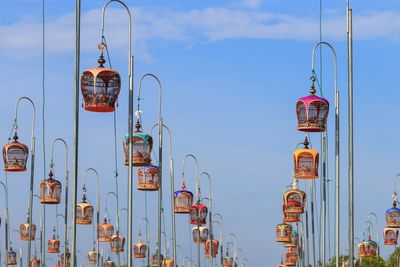 Street lights hanging on pole in city against blue sky