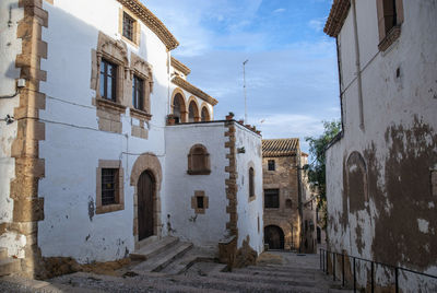 Alley amidst buildings in town against sky