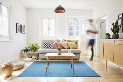 Man walking in bright modern living room in an old country house