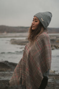 Portrait of young woman standing at beach