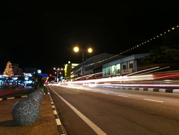 Light trails on road against sky at night