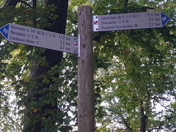 Low angle view of signboard against trees