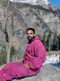 Portrait of young man standing against mountain. worth to visit harma pass in manali