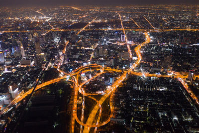 High angle view of city lit up at night