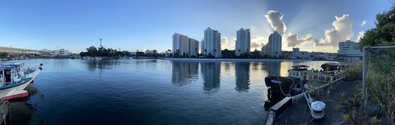 Panoramic view of buildings by river against sky