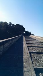 Empty road against clear blue sky