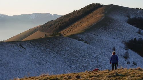 Rear view of man on mountain against sky