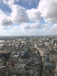 High angle view of city buildings against cloudy sky