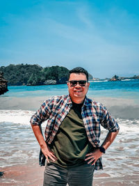 Portrait of young man standing against sea