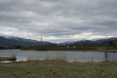 Scenic view of lake by mountains against sky