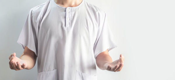 Midsection of man standing against white background